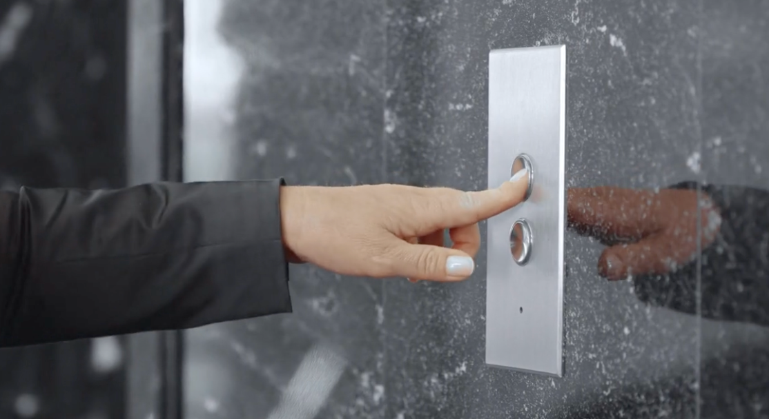 Round elevator call buttons installed in a narrow landing panel