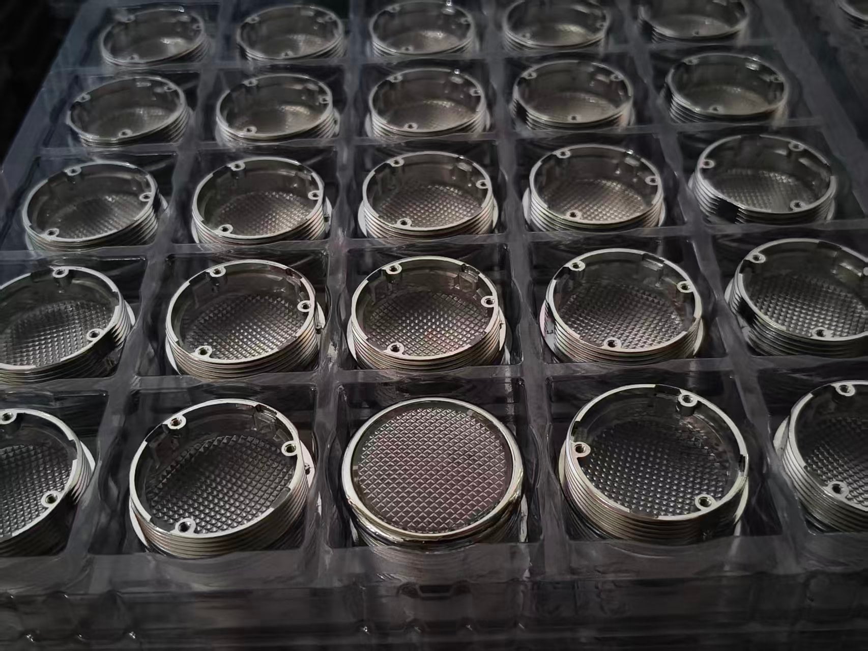 Round elevator button housings arranged in production trays