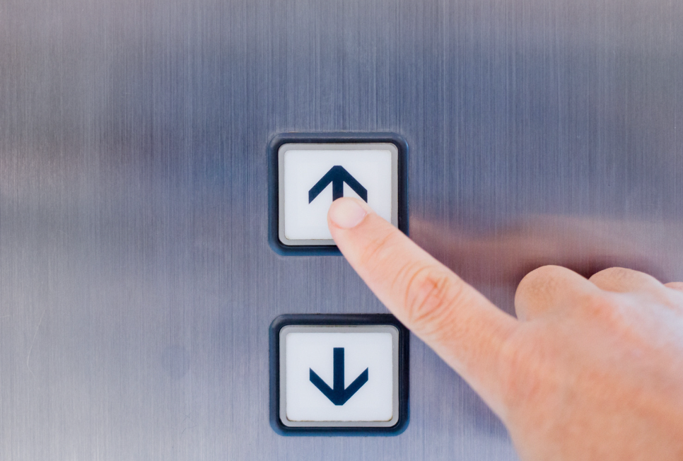 Square elevator call buttons installed in a metal panel
