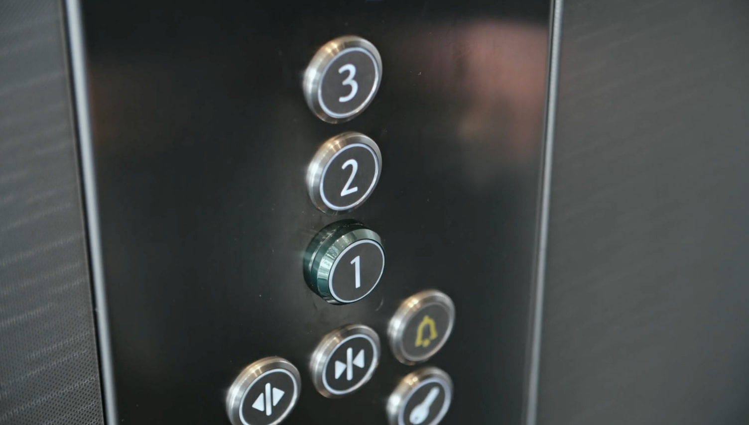 Round elevator buttons installed in a dark operating panel