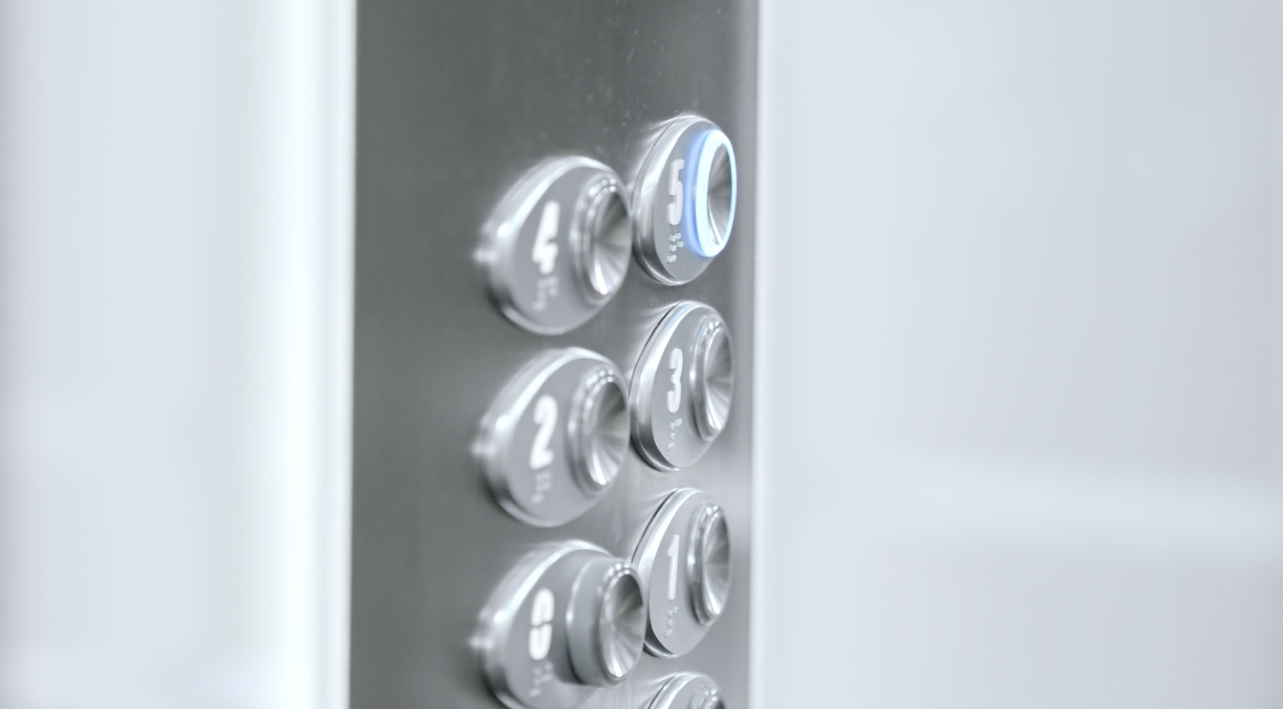 Round metallic elevator buttons installed in a bright operating panel